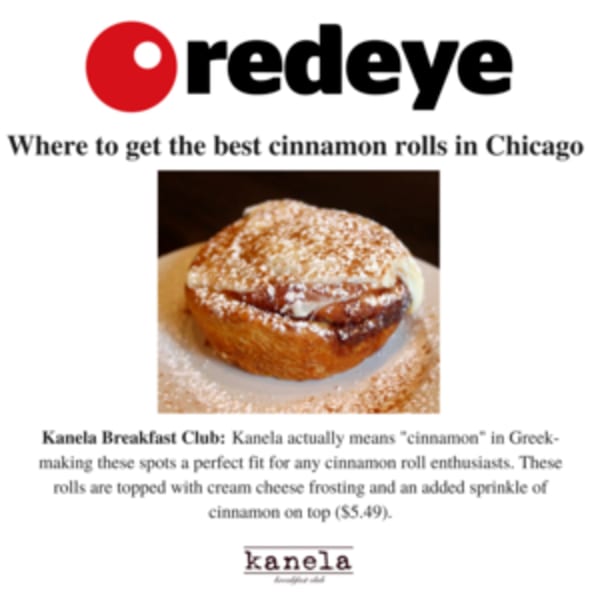 A Kanela Breakfast Club cinnamon roll with cream cheese frosting and powdered sugar on a white plate.